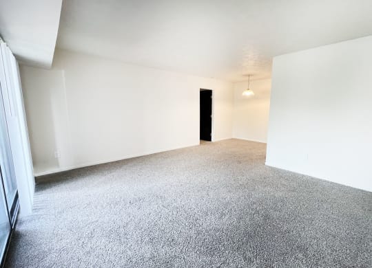 an empty living room with white walls and carpet at Four Worlds Apartments, Cincinnati