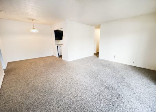 an empty living room with white walls and carpet at Four Worlds Apartments, Cincinnati, OH