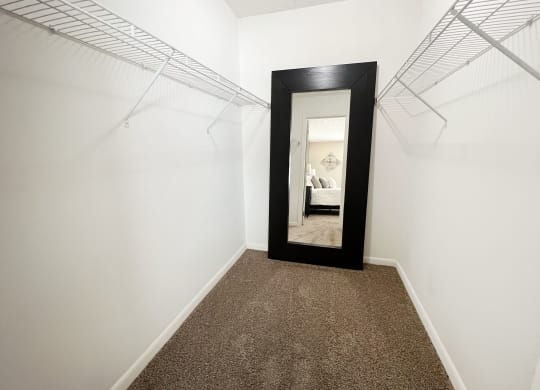a hallway with a mirror and white walls and carpet  at Fox Run Apartments, Cincinnati, OH, 45236