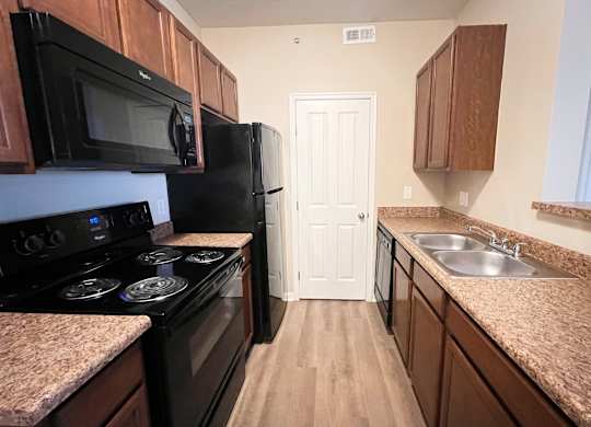a kitchen with black appliances and granite counter tops