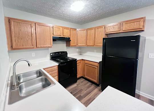 A kitchen with wooden cabinets and black appliances.
