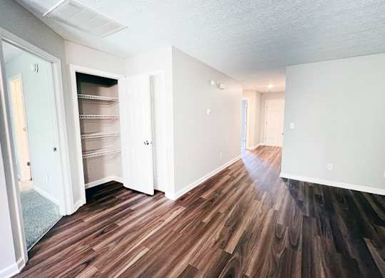 A room with wood flooring and white walls.