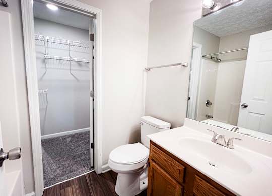 A white toilet sits in a bathroom next to a walk-in shower.