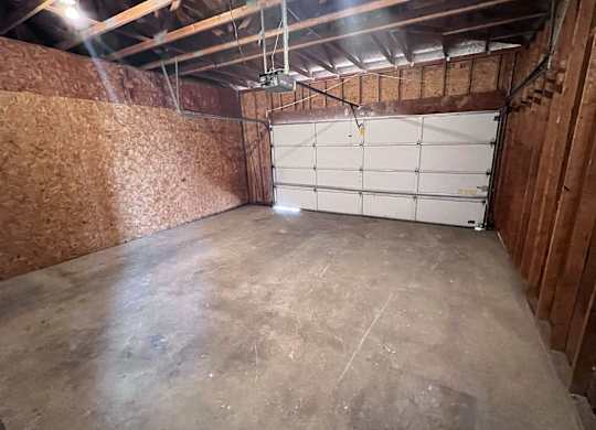 A garage with a white door and wooden walls.