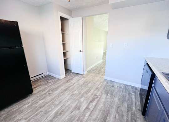 A kitchen with a black fridge and a sink.