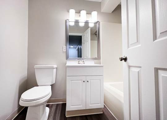 A white toilet sits next to a white sink in a bathroom.