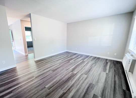 A room with a wooden floor and white walls.