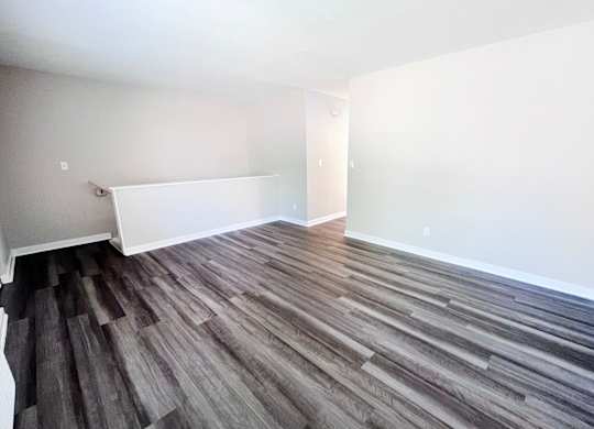 A room with wooden flooring and white walls.