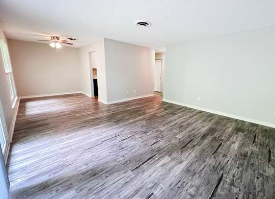 A room with wooden flooring and white walls.
