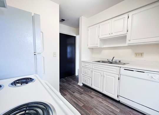 A white kitchen with a stove and sink.