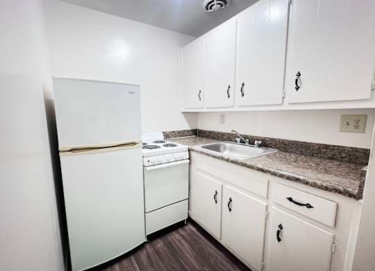 Efficiency: A kitchen with white appliances and cabinets.