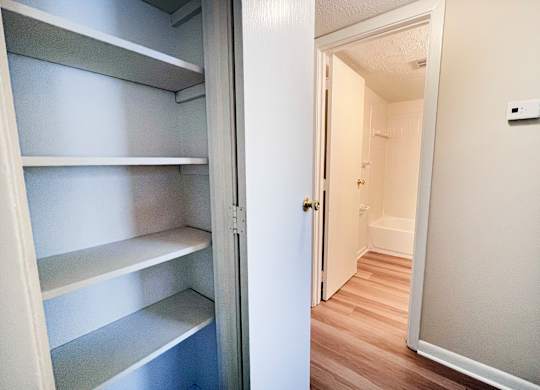 A white refrigerator with four shelves is open.