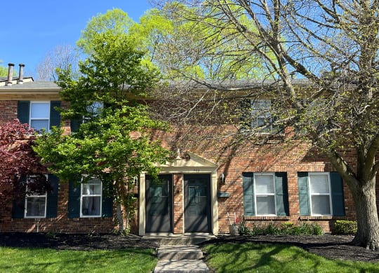 a brick house with a tree in front of itat Revere Village Apartments, Centerville, Ohio