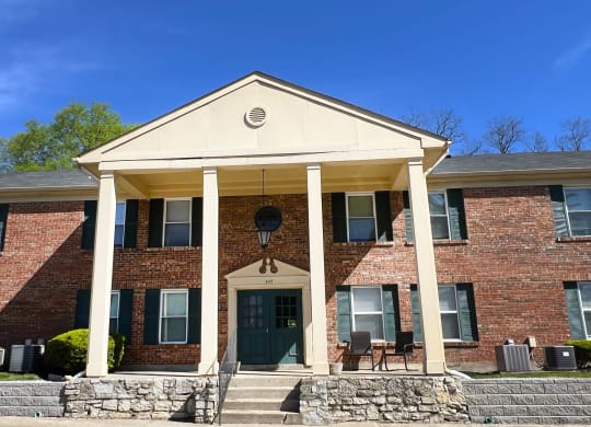 the front of a brick building with columns and a porchat Revere Village Apartments, Centerville, Ohio