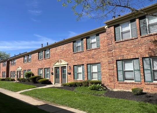 a brick apartment building with a sidewalk and grassat Revere Village Apartments, Centerville, 45458