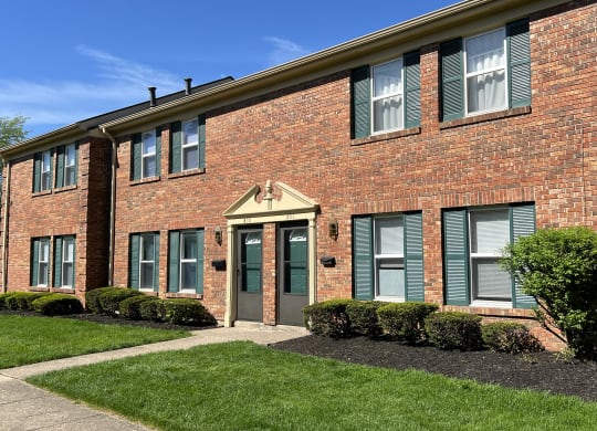 the front of a brick building with green shutters and grassat Revere Village Apartments, Ohio, 45458