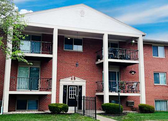 A red brick building with a black gate in front.