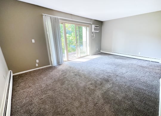 an empty living room with carpet and a sliding glass door  at Crown Pointe Apartments, Kentucky, 41014