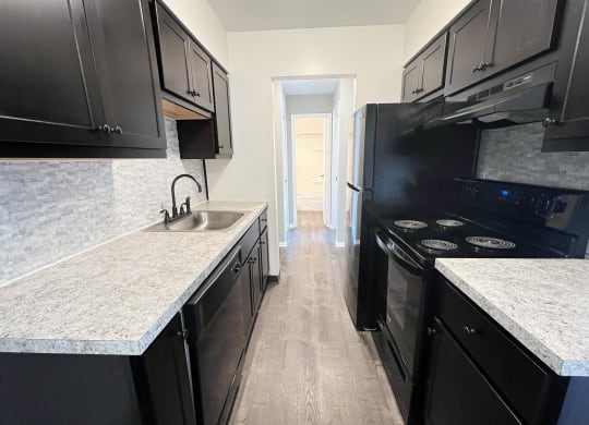 a kitchen with black cabinets and white counter tops and a black stove and refrigerator at Crown Pointe Apartments, Kentucky, 41014
