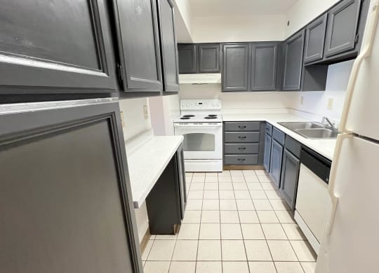 an empty kitchen with black cabinets and white appliances at Indian Lookout Apartments, Cincinnati, OH, 45238