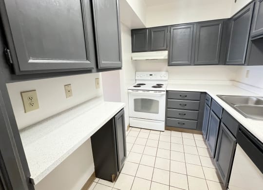 a kitchen with black cabinets and white appliances and a sink at Indian Lookout Apartments, Cincinnati