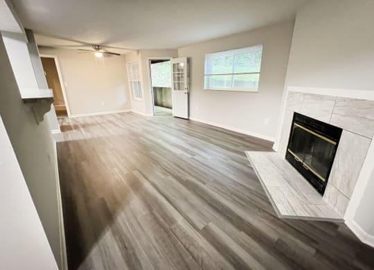 an empty living room with a fireplace and wooden floors at The Vinings Apartments, Cincinnati, Ohio