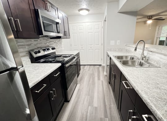 a kitchen with granite counter tops and stainless steel appliances at The Vinings Apartments, Cincinnati, Ohio