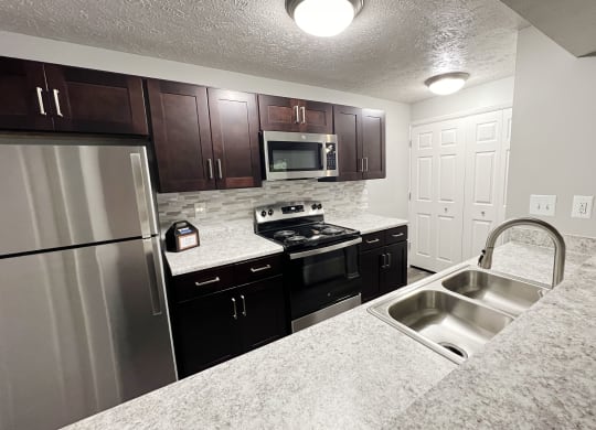 a kitchen with stainless steel appliances and granite counter tops at The Vinings Apartments, Cincinnati, OH, 45245