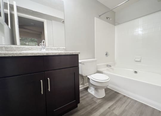 a bathroom with a toilet and a tub and a sink at The Vinings Apartments, Cincinnati, 45245