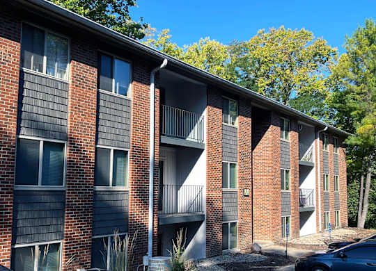 A row of red brick apartment buildings with balconies.