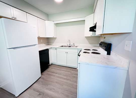 A kitchen with white appliances and cabinets.
