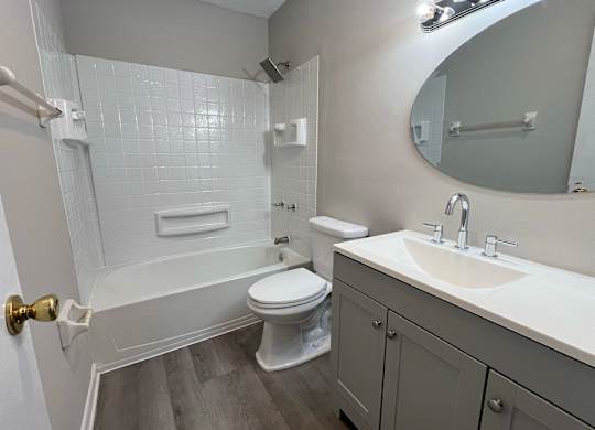 A white bathroom with a toilet, sink, and bathtub.