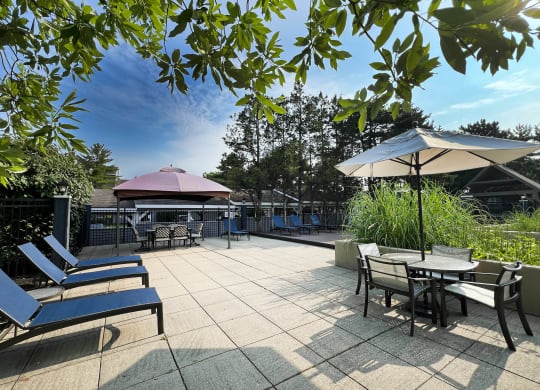 a patio with tables and chairs and umbrellas at Deercross Apartments, Cincinnati, Ohio