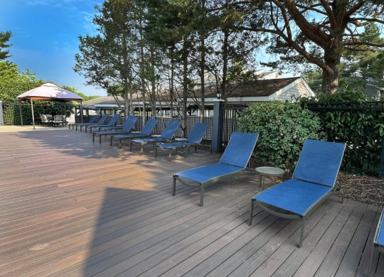 a row of blue lounge chairs on a wooden deck at Deercross Apartments, Ohio, 45236