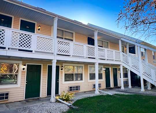 A row of houses with white balconies and green doors.