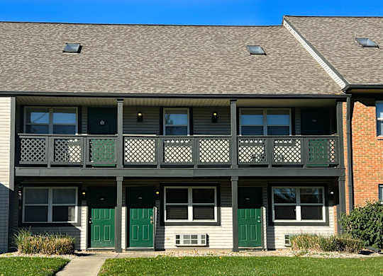 A building with a grey roof and green doors.