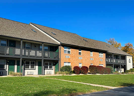 A building with a grey roof and a red brick wall.