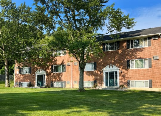 a red brick apartment building with green grass and trees at Sharondale Woods Apartments, Ohio, 45241