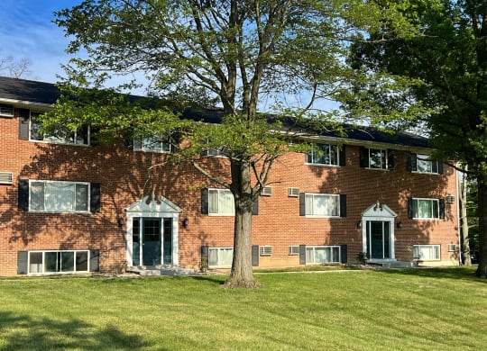 a red brick house with a tree in front of it at Sharondale Woods Apartments, Cincinnati, OH