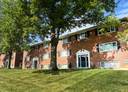 a large brick building with a tree in front of it at Sharondale Woods Apartments, Cincinnati, OH, 45241