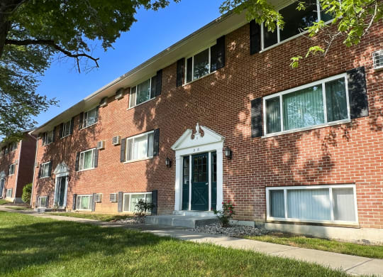 a red brick apartment building with a green door at Sharondale Woods Apartments, Cincinnati, OH