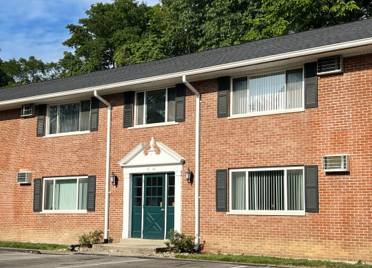 the front of a brick house with a green door at Sharondale Woods Apartments, Ohio, 45241