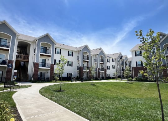 an exterior view of an apartment complex with grass and trees at Parkway Trails, Florence, Kentucky