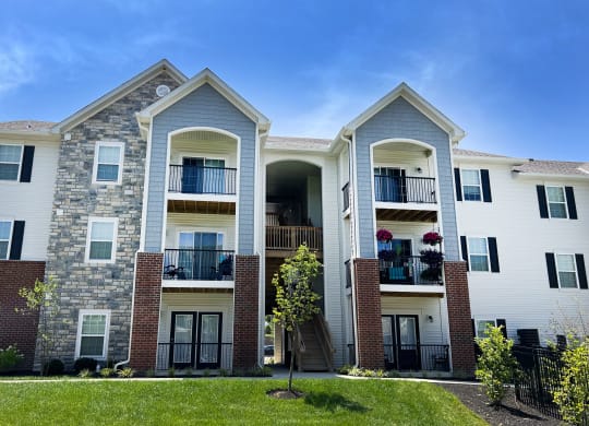 two story apartment building with brick and stone exterior on a sunny day