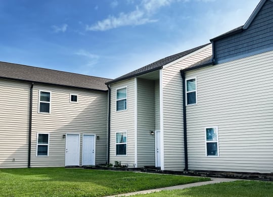 a row of houses with white siding and a grass yard at 450 on Keeneland Apartments, Richmond, KY 40475