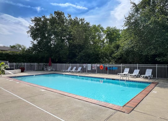 a swimming pool with chairs and a fence around it at 450 on Keeneland Apartments, Richmond, KY 40475
