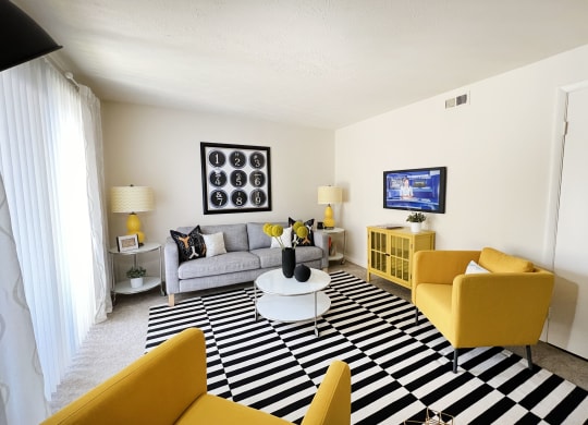 a living room with yellow furniture and a black and white rug at Miamisburg by the Mall, Ohio