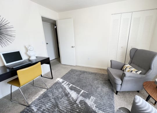 a living room with a chair and a desk with a laptop at Miamisburg by the Mall, Miamisburg, OH, 45342