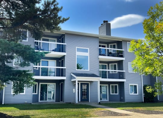 a gray apartment building with a lawn and trees at Deercross Apartments, Cincinnati, OH 45236