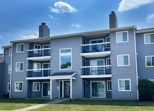 a blue apartment building with balconies on a sunny day at Deercross Apartments, Cincinnati, Ohio